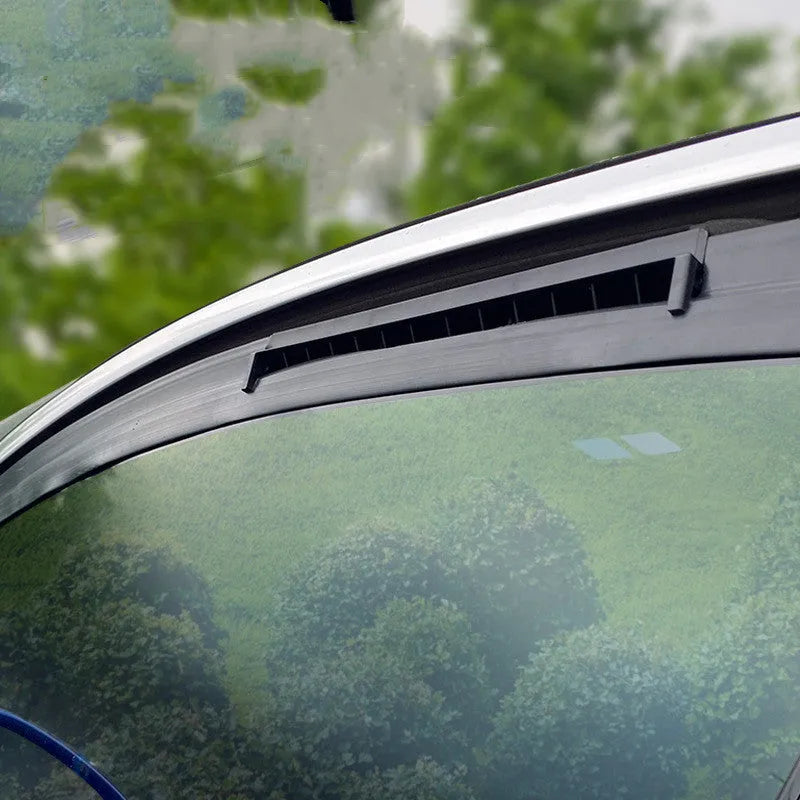 Black and white car ventilation fan with USB power cord on a car dashboard.