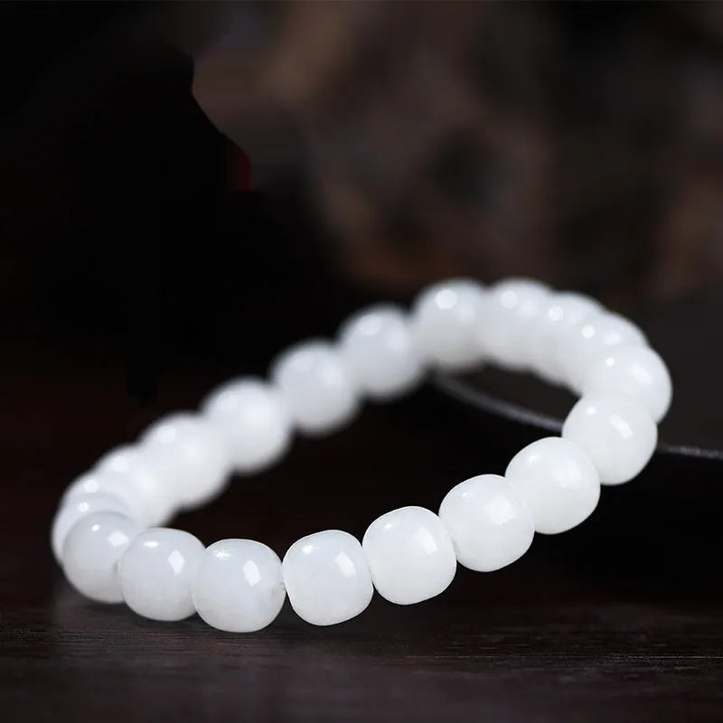 White Hetian jade barrel bead bracelet on a wrist, showing three bead size options.