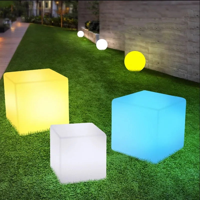 A modern square white LED cube stool light for outdoor garden use.