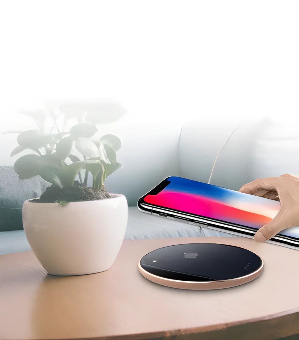 Ultra-thin aluminium wireless charging pad in rose gold colour on a wooden desk.
