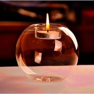 Clear hollow glass spherical candle holder in European style on a table.