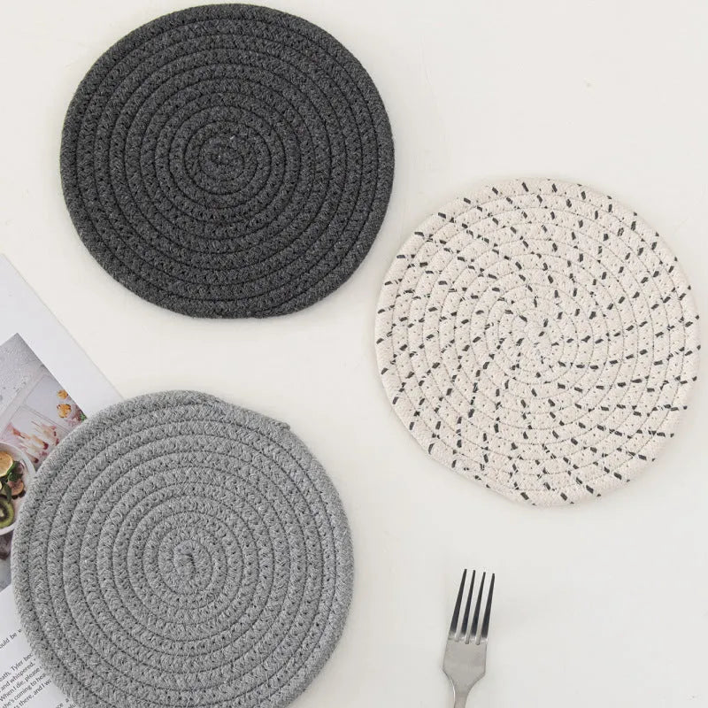 Three round cotton cord coasters in blue colour set on wooden table