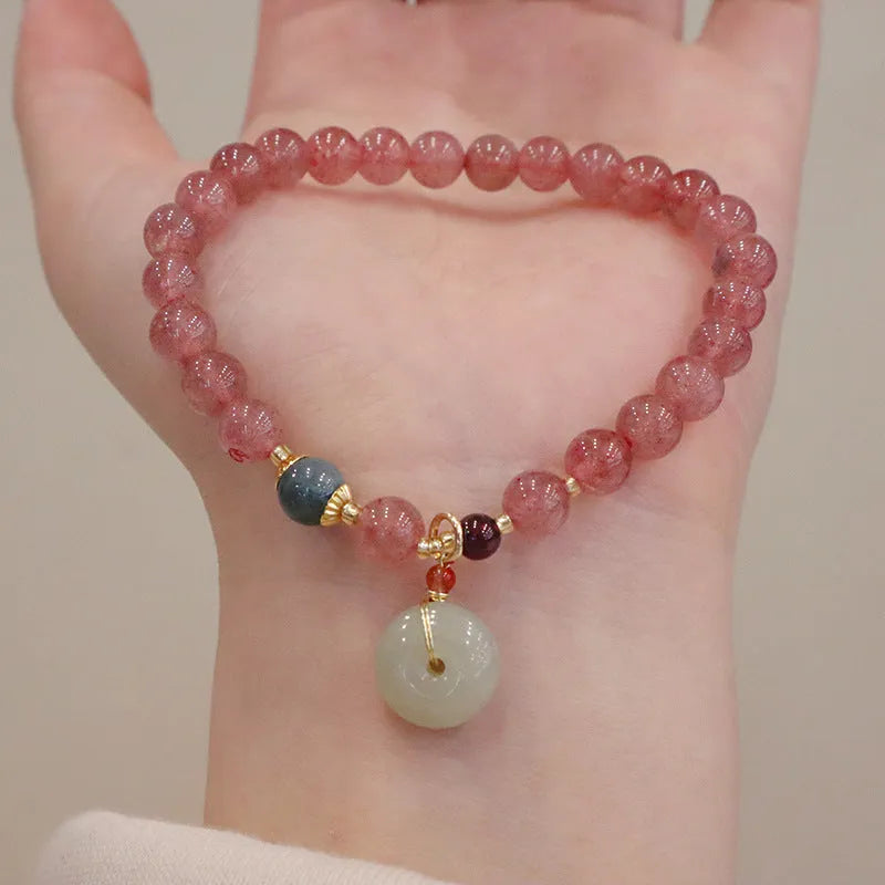 Women's strawberry quartz bracelet with geometric beads, peace buckle closure, and lucky bag charms