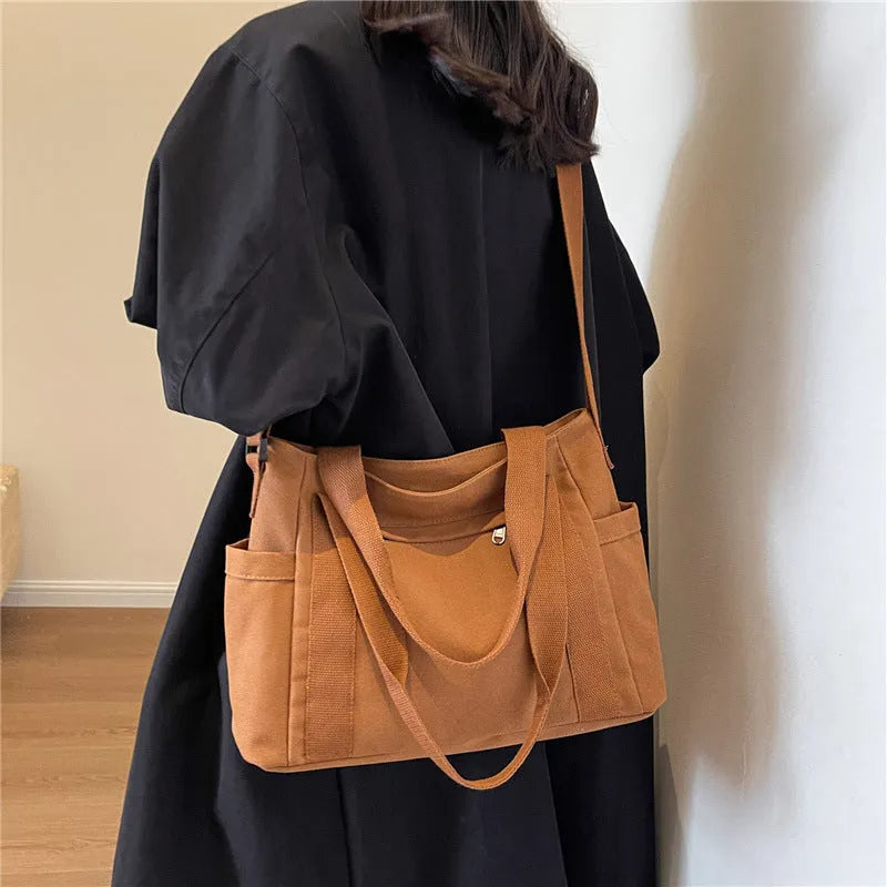 Large canvas shoulder bag for women in solid colour with external pocket and internal phone compartment