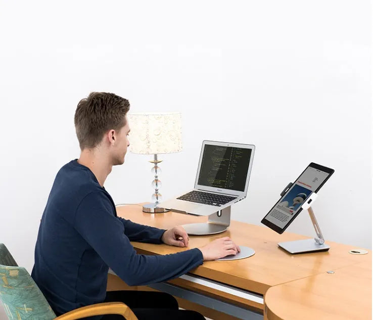 Foldable aluminium desktop phone and tablet holder in silver showing 360-degree rotation