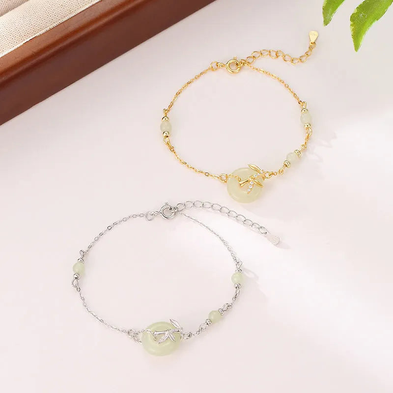 Women's antique style Hetian Jade bracelet with a silver safety buckle on a wrist.