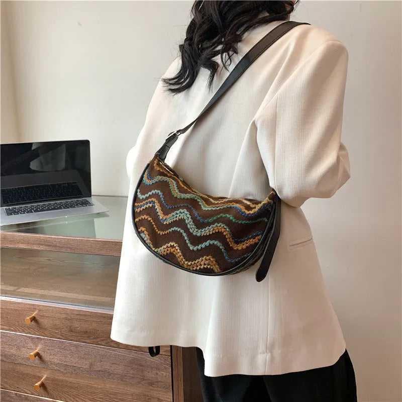 Women's knitted straw woven crossbody bag showing woven texture and internal phone/document compartments