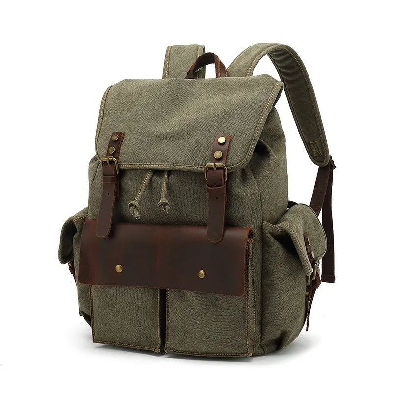 Retro canvas backpack in army green colour with antique bronze hardware, shown with a laptop to scale.