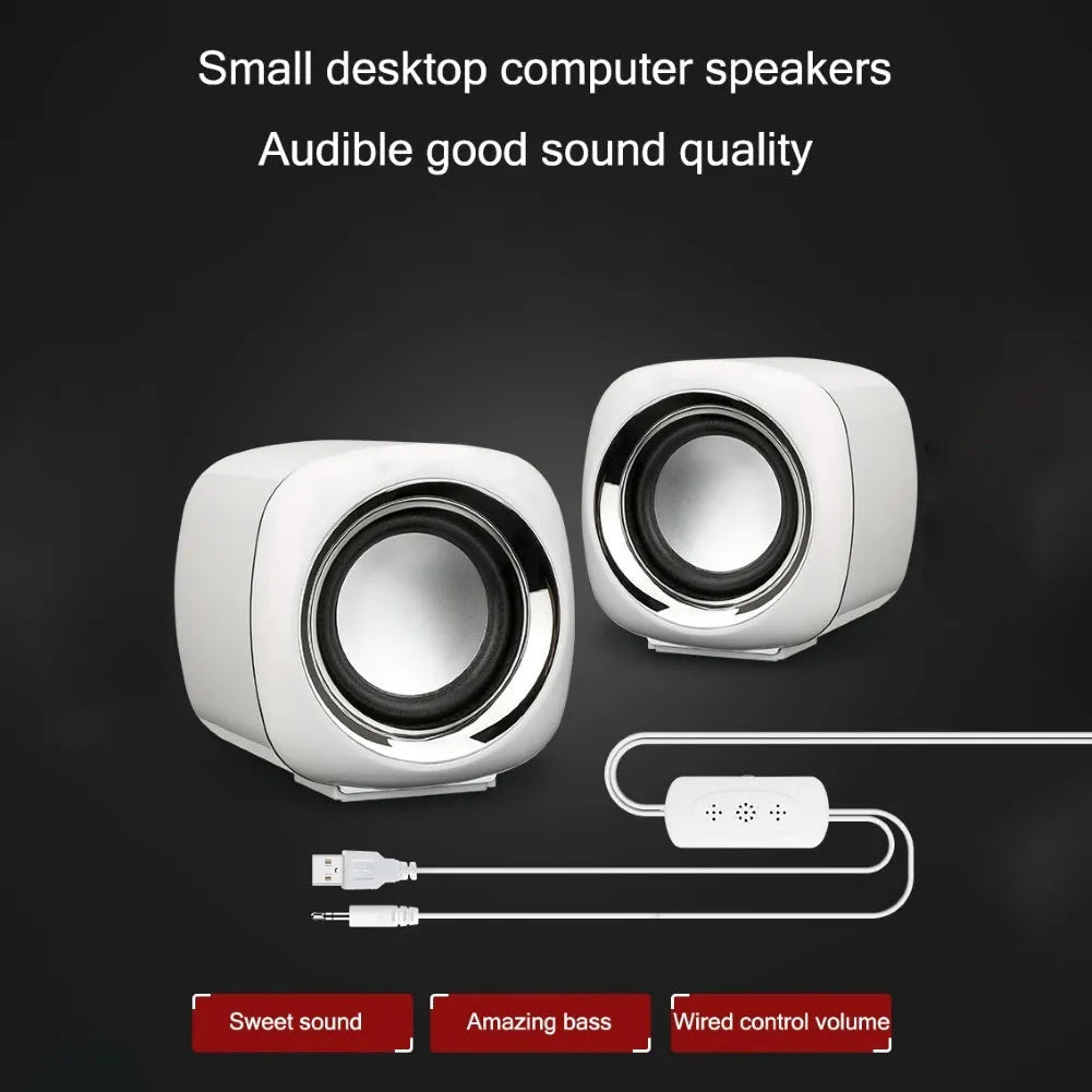 A pair of small black wired desktop computer speakers with a volume scroll wheel.