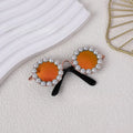 Pearl-rimmed round sunglasses for cats and dogs in multiple colours on a festive background.
