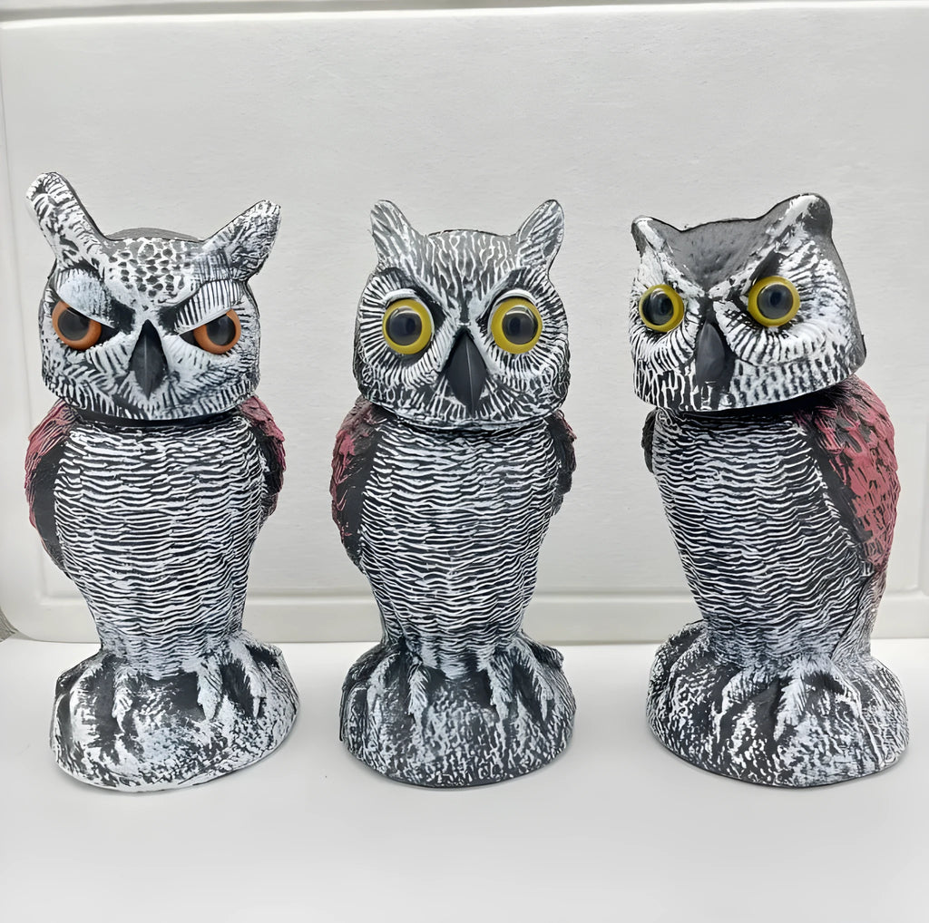 Polyethylene artificial owl bird scarer ornament with moving head, shown in a garden setting.