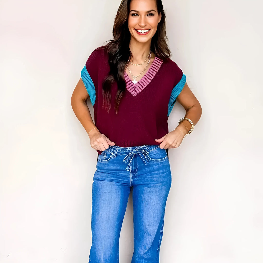 Burgundy and black loose V-neck sweater with cuffed short sleeves on a neutral background