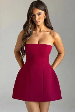 Black backless tube dress with slim fit and short A-line skirt on a model.