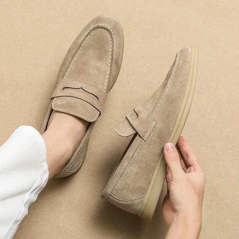Men's beige leather slip-on casual shoes with a round toe and rubber sole on a neutral background.