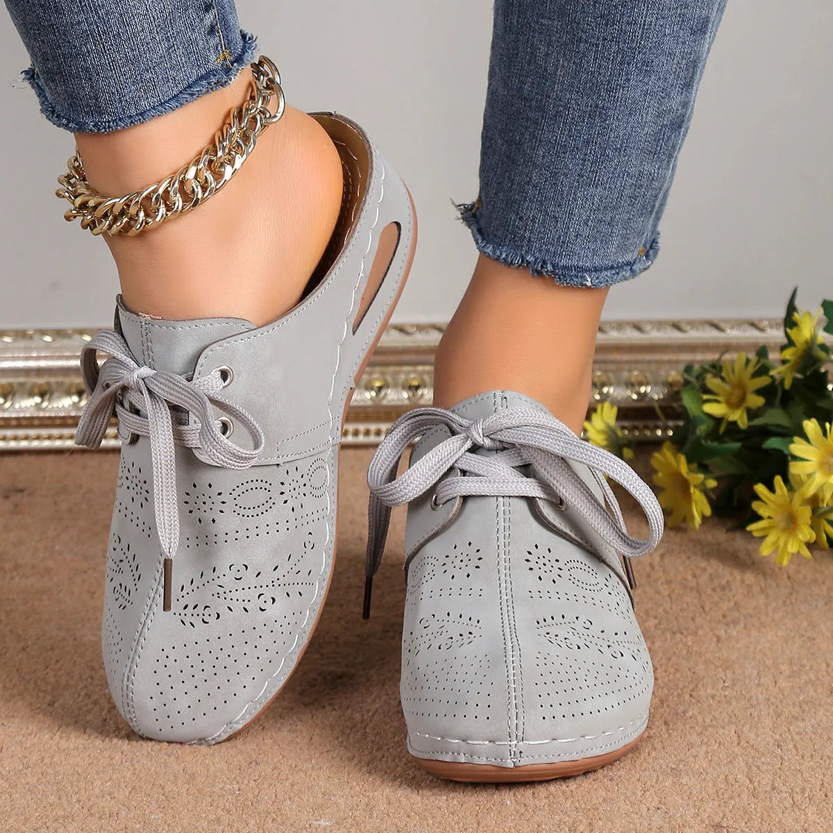 Women's black lace-up baotou slippers with a suede upper and rubber sole on a neutral background.
