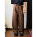 Men's loose-fitting straight-leg trousers in brown and black colours on a hanger