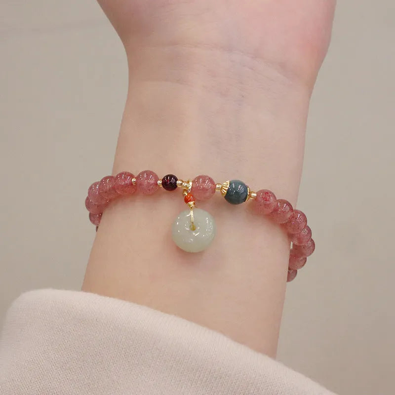 Women's strawberry quartz bracelet with geometric beads, peace buckle closure, and lucky bag charms