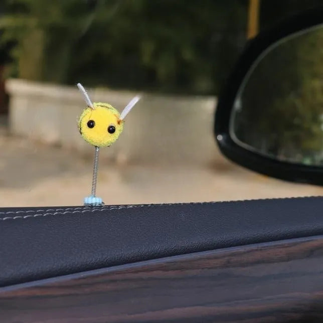 Small plush swing spring bee car decoration ornament on a 3cm scale grid.