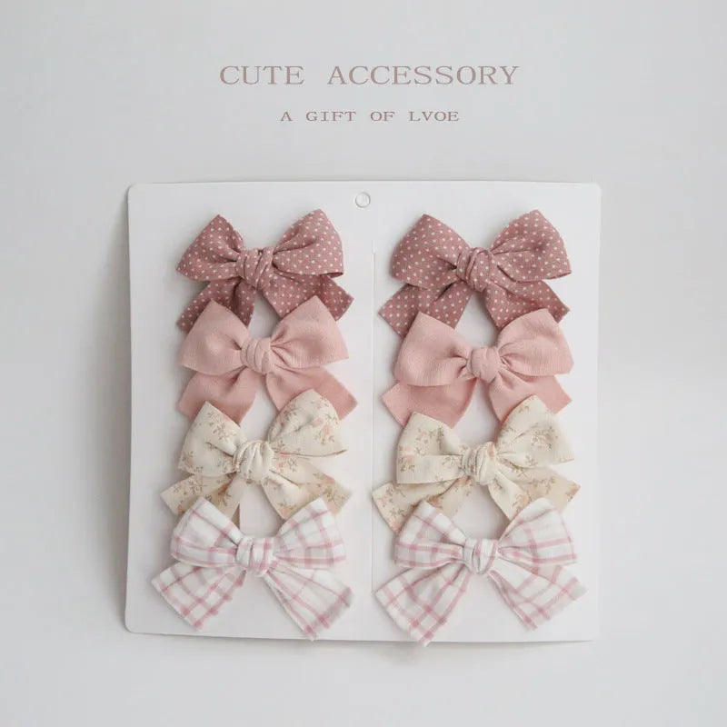 Set of children's cloth hair clips with a dovetail bow design in various colours.