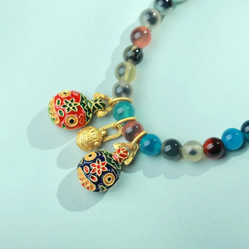 Women's agate snake bracelet with copper coin detailing and coloured glaze accents in geometric design