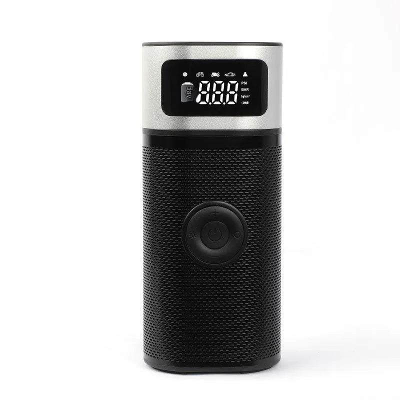Black portable wireless air pump with digital display, LED light, and attached inflation tube on a textured surface.