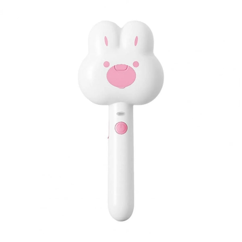 Rechargeable pink cartoon-design steam brush comb for grooming cats and dogs on a table.