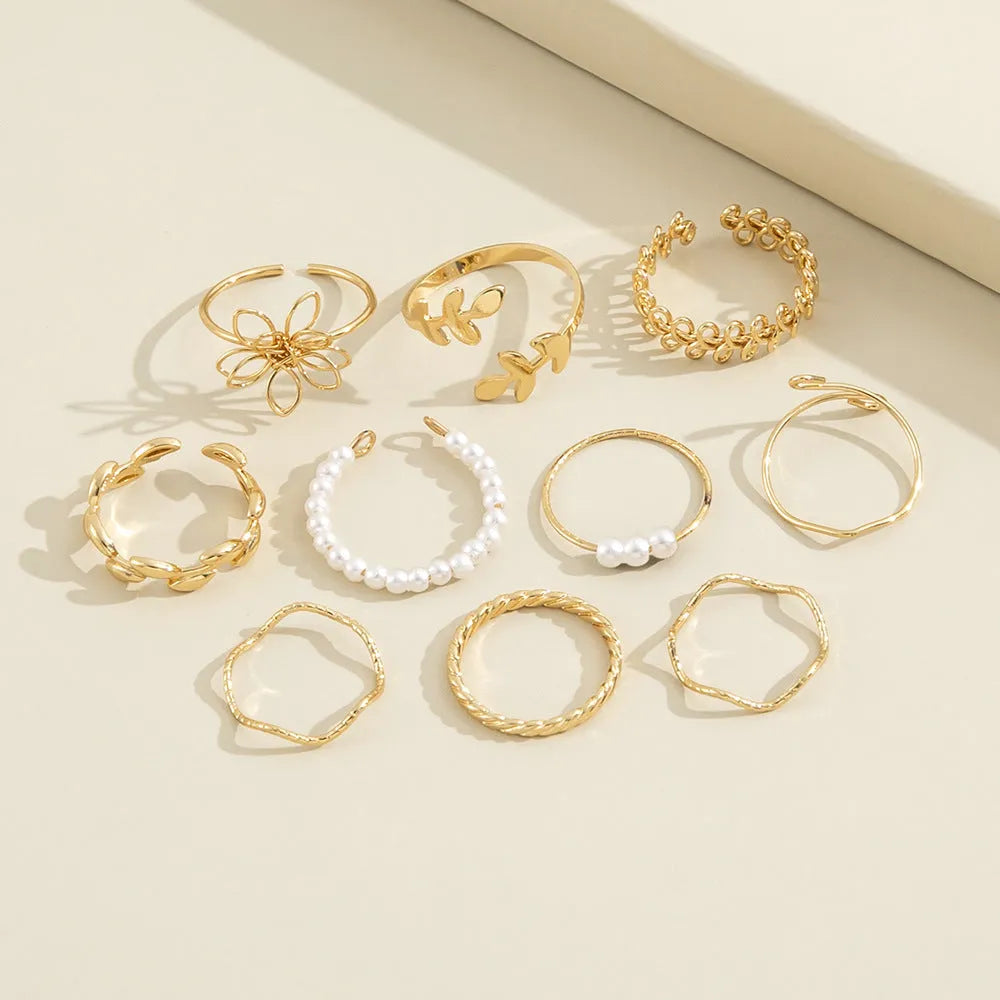 Gold coloured openwork flower shape alloy ring with a glossy electroplated finish.