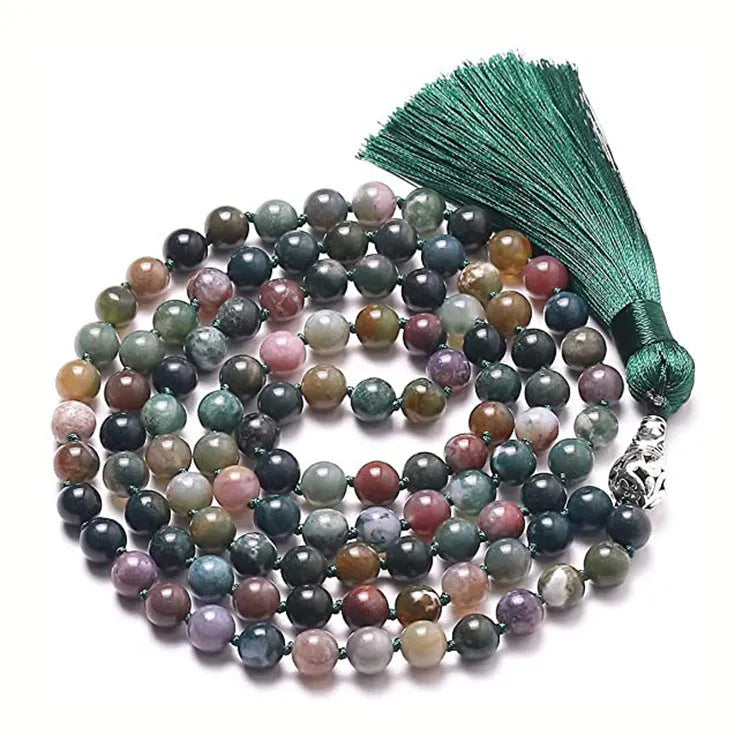 Long blue patterned agate and stone tassel necklace with geometric beads on a white background.