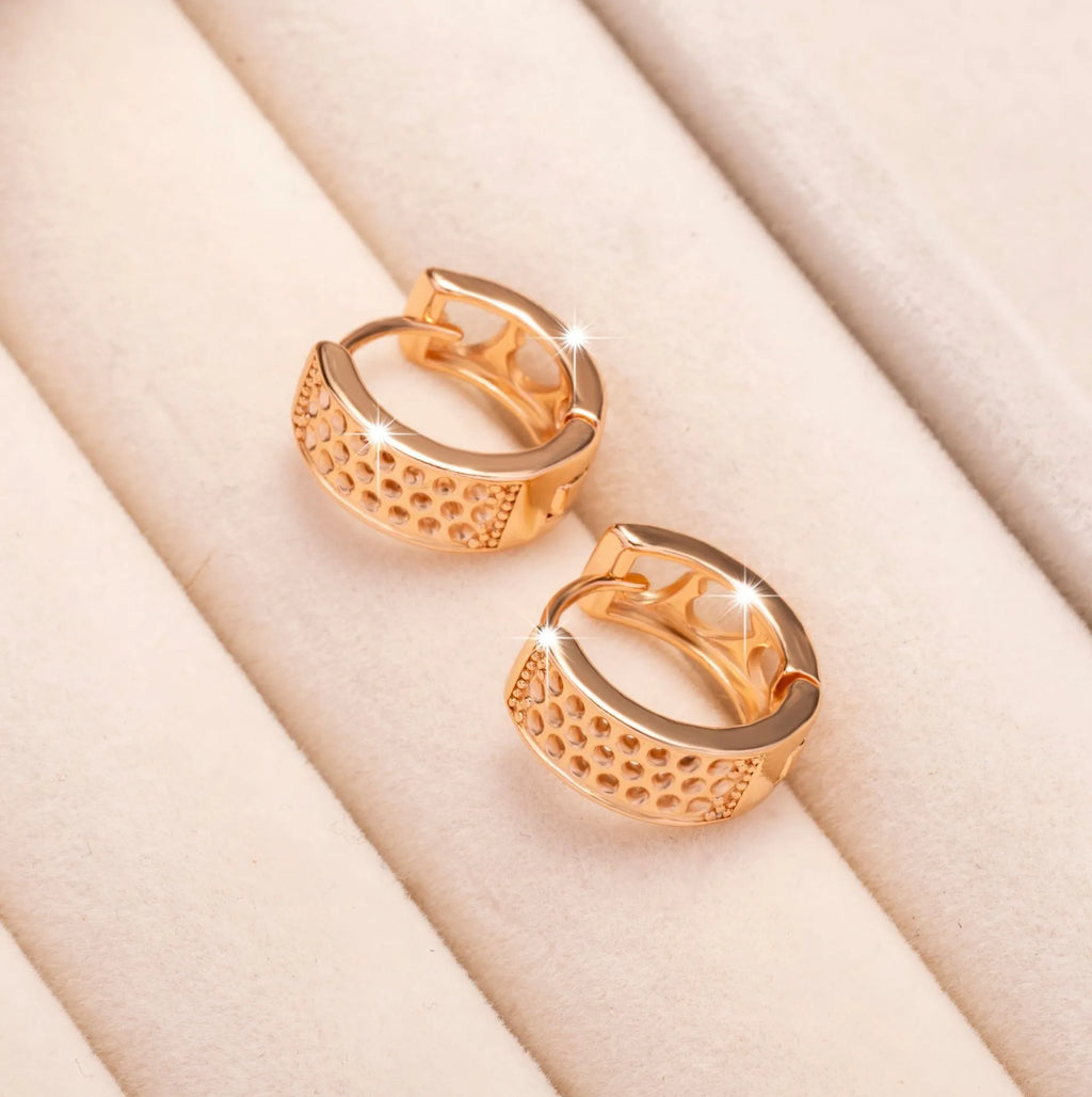 Rose gold coloured circular earrings with a hollowed-out three-heart design.