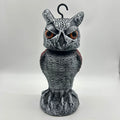 Polyethylene artificial owl bird scarer ornament with moving head, shown in a garden setting.