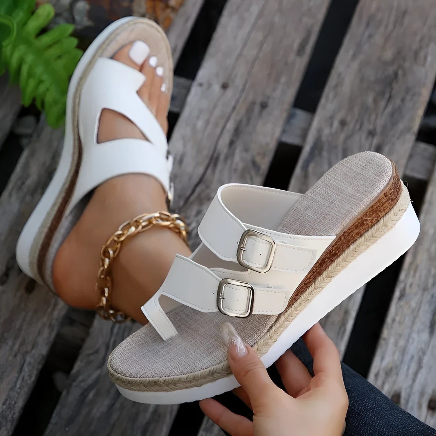 White casual wedge sandals with woven patent leather upper and peep toe design on a foot.