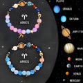 Set of two natural stone beaded bracelets with zodiac sign designs laid flat.