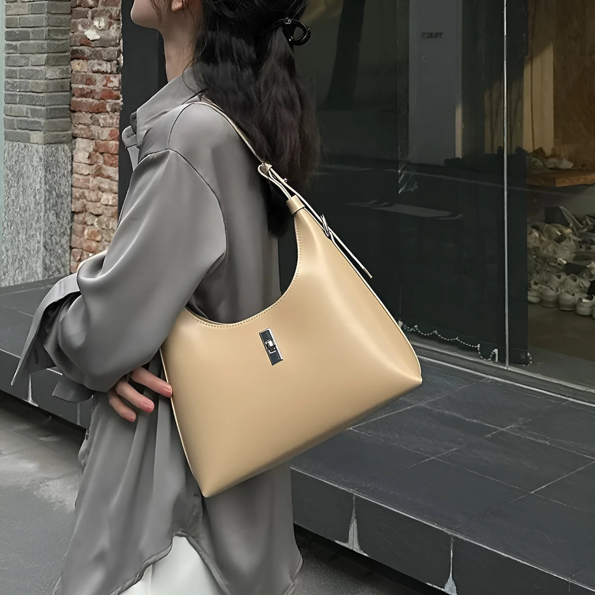 Soft genuine leather dumpling-shaped crossbody bag in apricot with sewing thread detail.