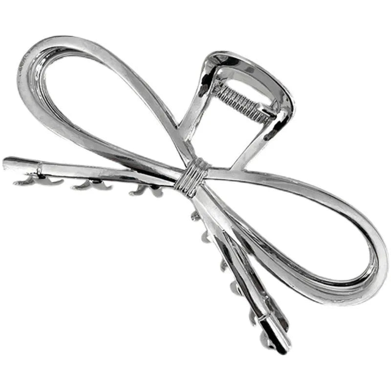 Gold and silver alloy hair barrettes with a bow design for women.