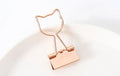 Gold plated decorative paper clip in a choice of flamingo, love, cloud, cat, cactus, or bow designs on a white background.