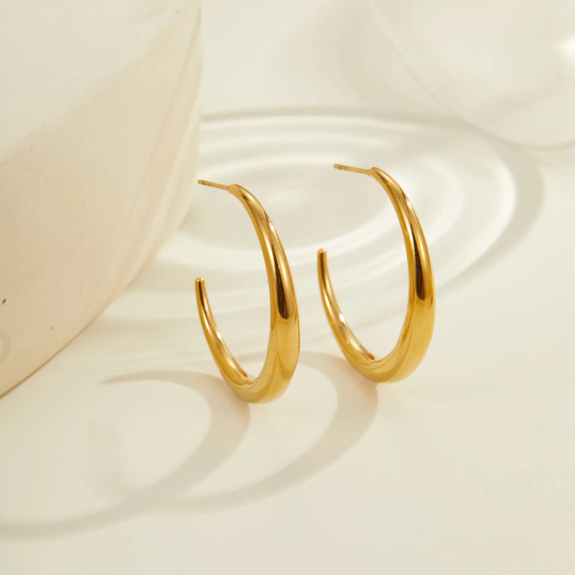 Simple geometric round hoop earrings in gold and steel finish made of stainless steel with 18K PVD plating