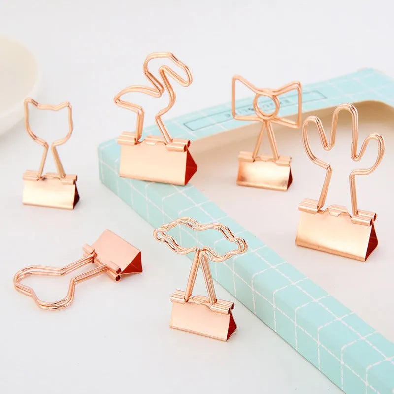 Gold plated decorative paper clip in a choice of flamingo, love, cloud, cat, cactus, or bow designs on a white background.