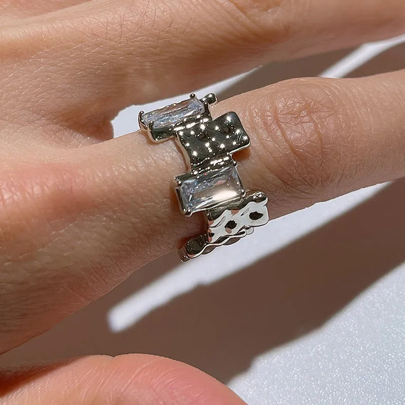 Silver geometric cross ring with open gemstone setting and three-dimensional decoration