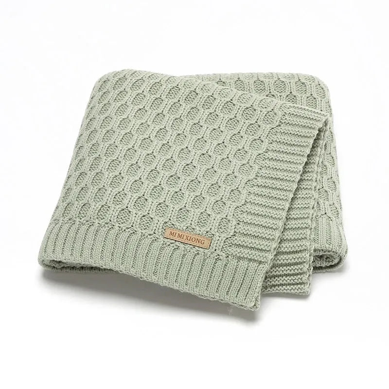Solid colour acrylic infant blanket with textured lines measuring 70×90cm in pink, beige, grey, or green