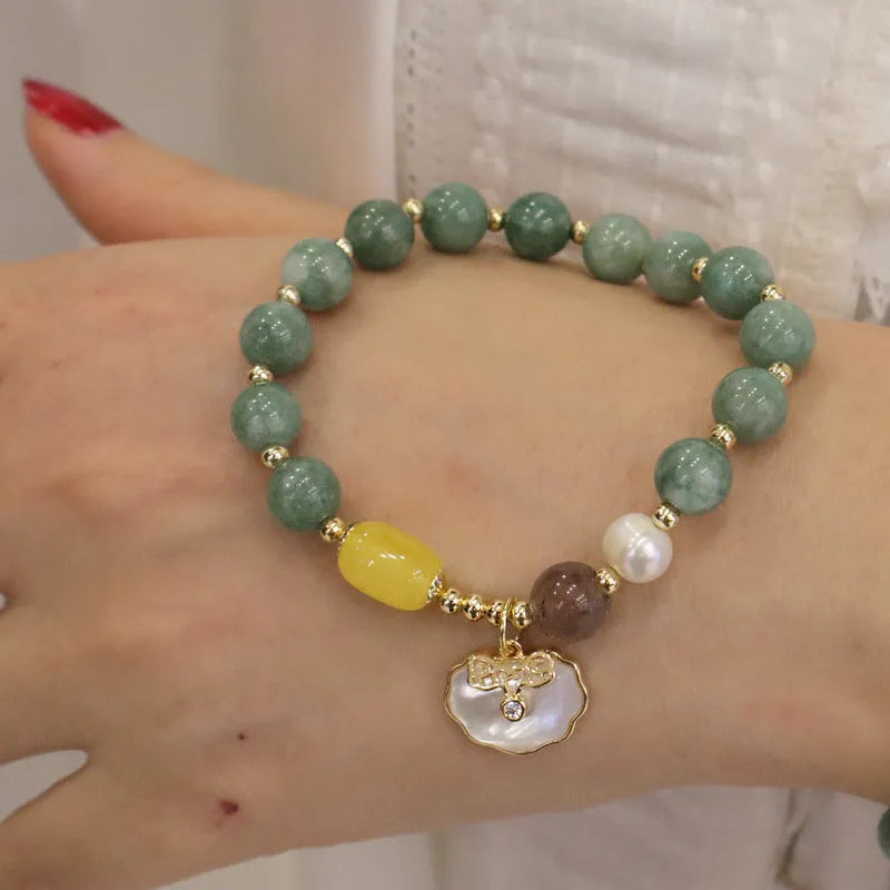 Green jade shell bracelet for women on a wrist, showing the natural stone colour and shell design detail.