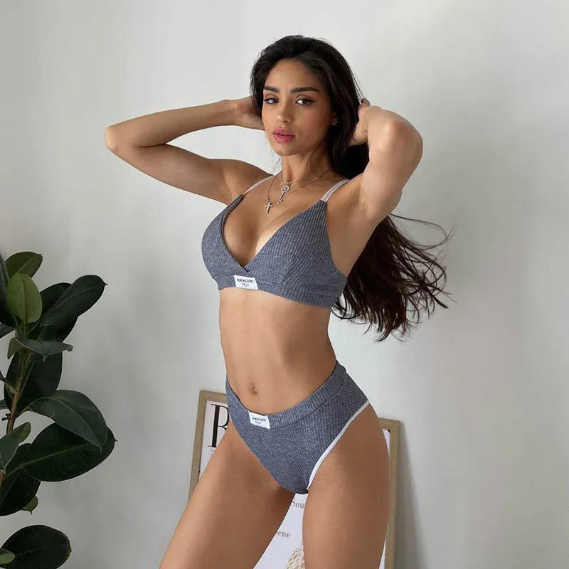 Women's black bikini set with white contrast binding and embroidery detail on the top and shorts.