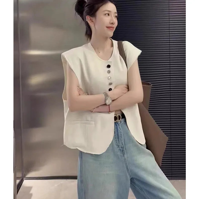 Women's solid colour polyester vest with pockets in loose fit and short 40cm length.