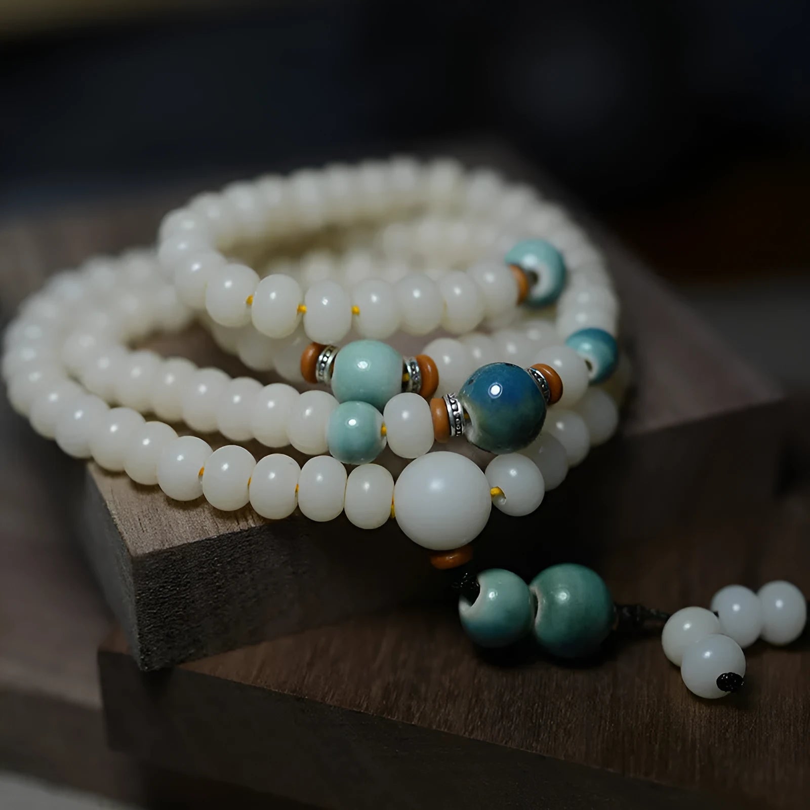 White jade bodhi seed bracelet with 108 flat round beads on a wrist.