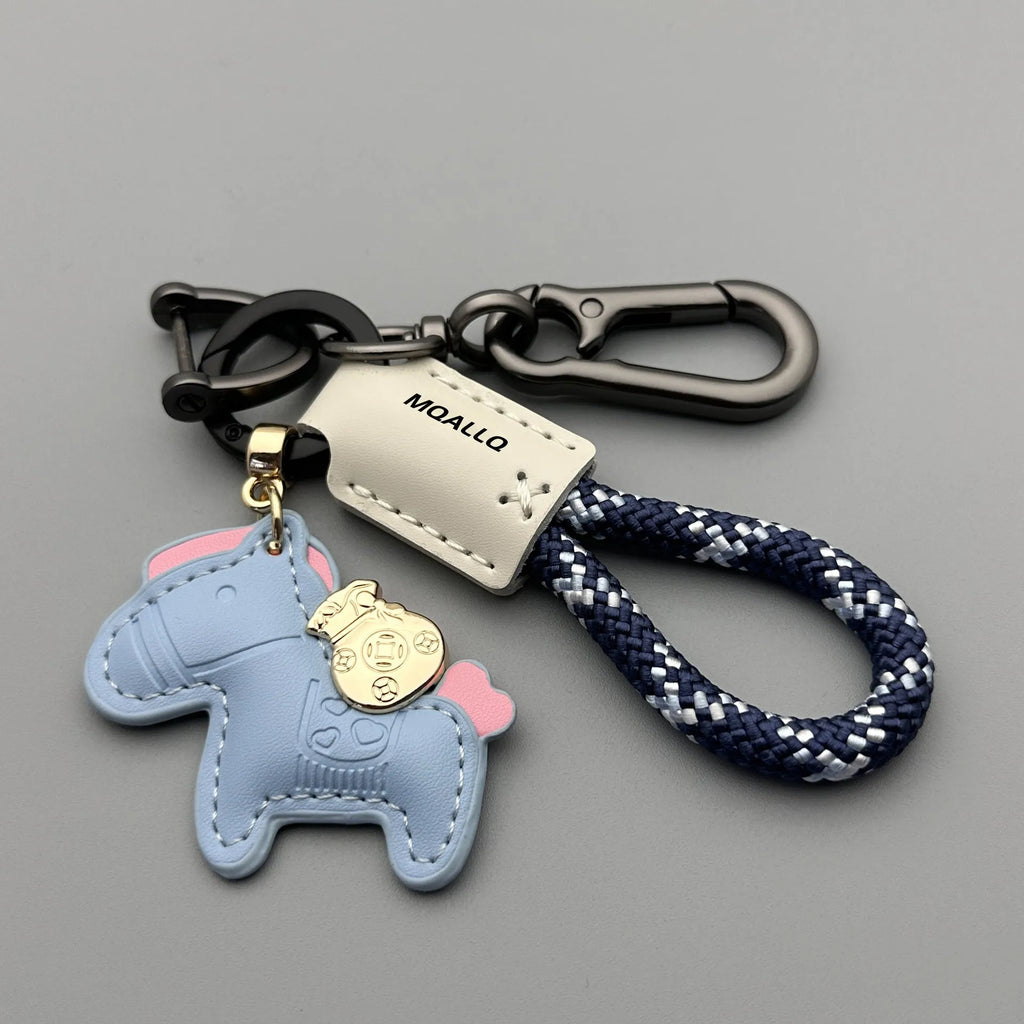 Handmade brown cowhide leather key ring with a gold-toned zinc alloy pony buckle and a green plaited flannelette rope.