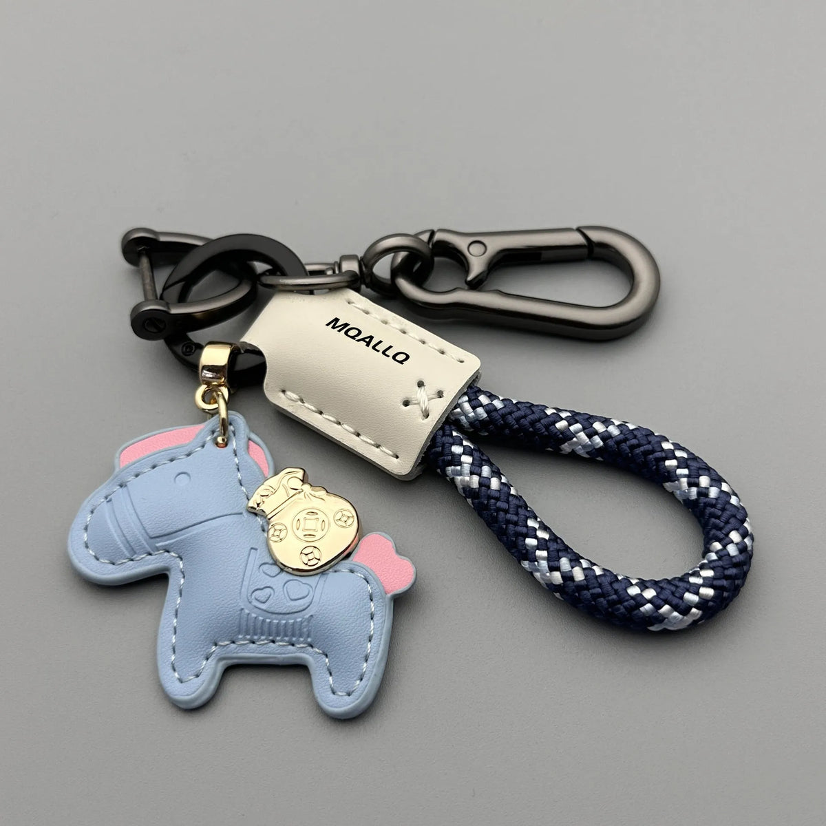 Handmade brown cowhide leather key ring with a gold-toned zinc alloy pony buckle and a green plaited flannelette rope.