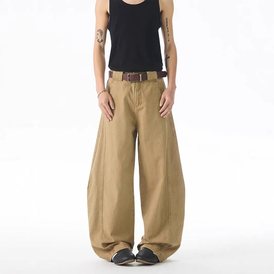 Brown men's straight-leg denim jeans with a loose fit and button fly on a neutral background.