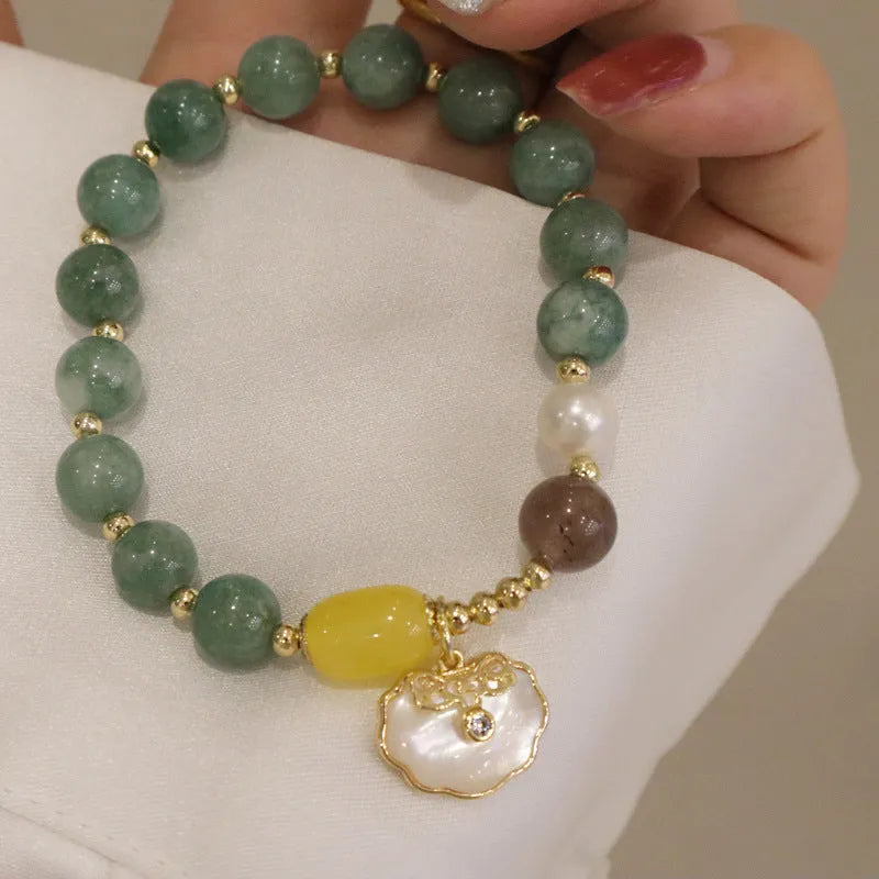 Green jade shell bracelet for women on a wrist, showing the natural stone colour and shell design detail.