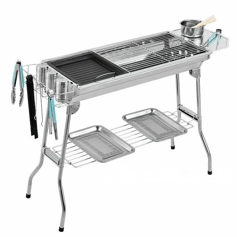 Large stainless steel portable folding barbecue oven set up outdoors.