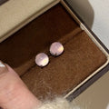 Chinese style chalcedony stud earrings with four-claw stone settings and round geometric design