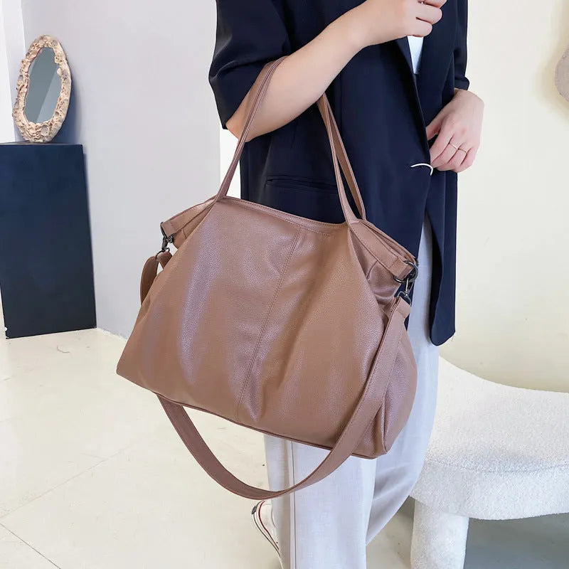 Large soft-surface PU leather messenger tote bag with long crossbody strap, shown in black colour